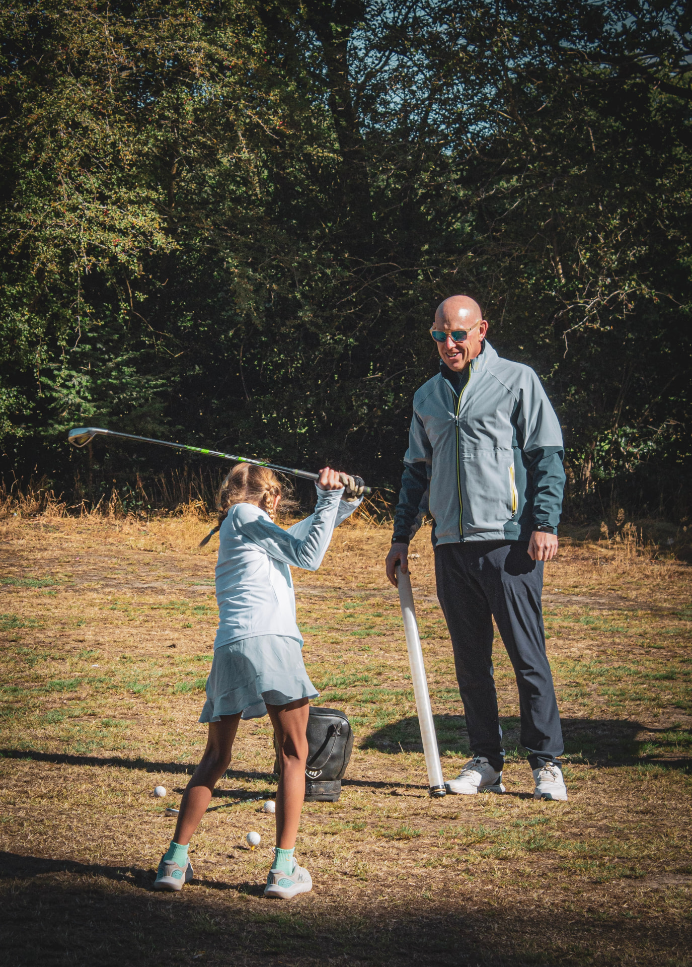 Kevin Evans watching a junior golfer complete her swing