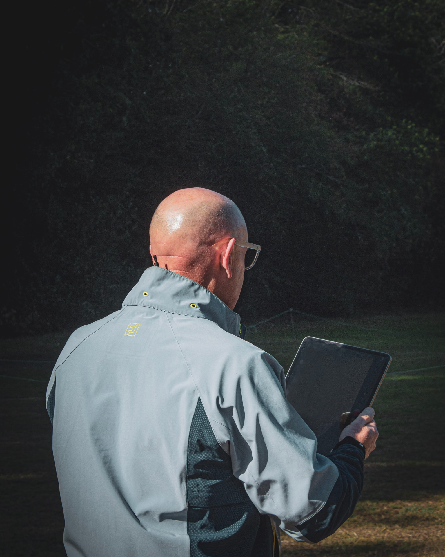 Kevin Evans reviewing a lesson on a tablet on the course