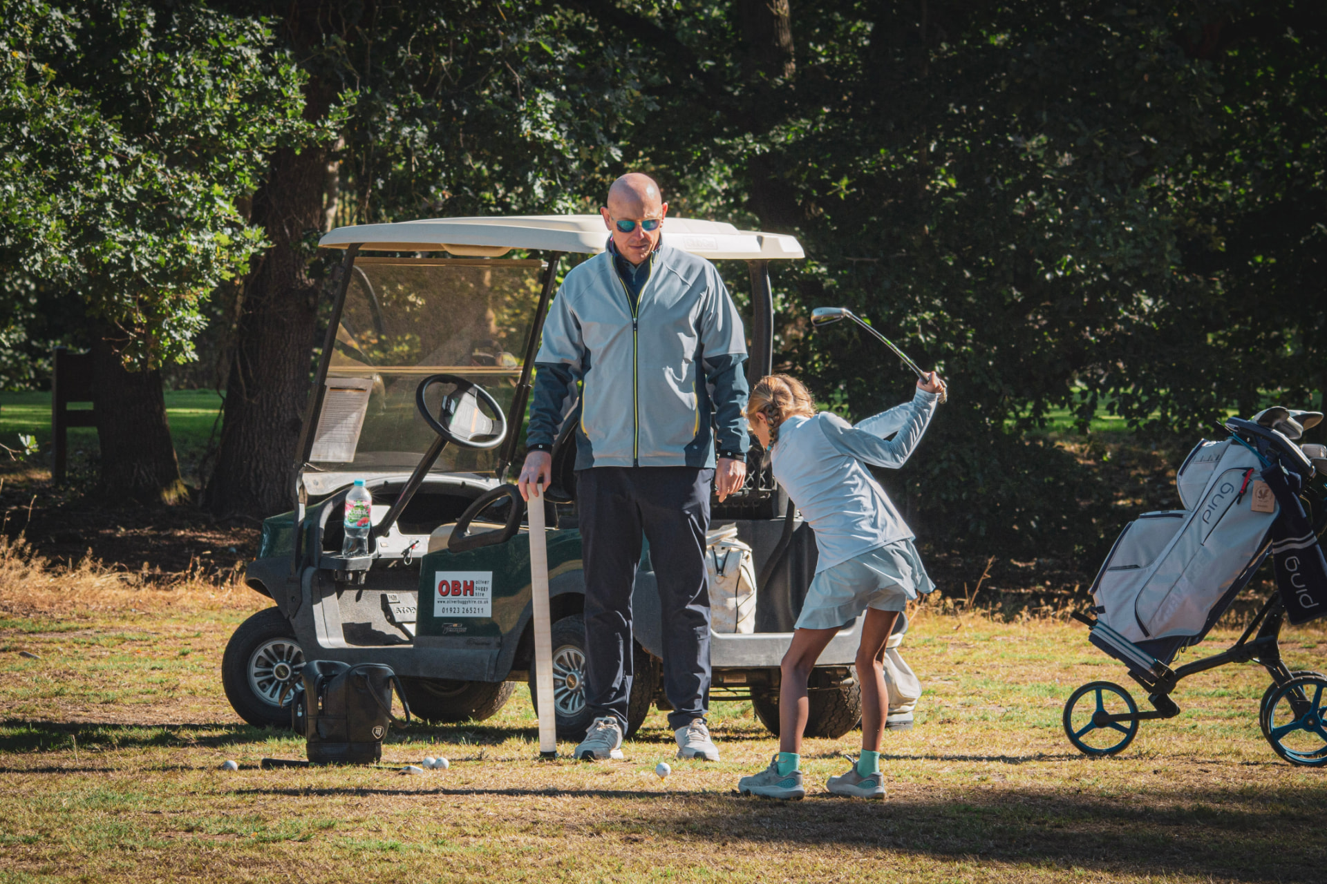 Kevin Evans coaching beside a golf cart on the range